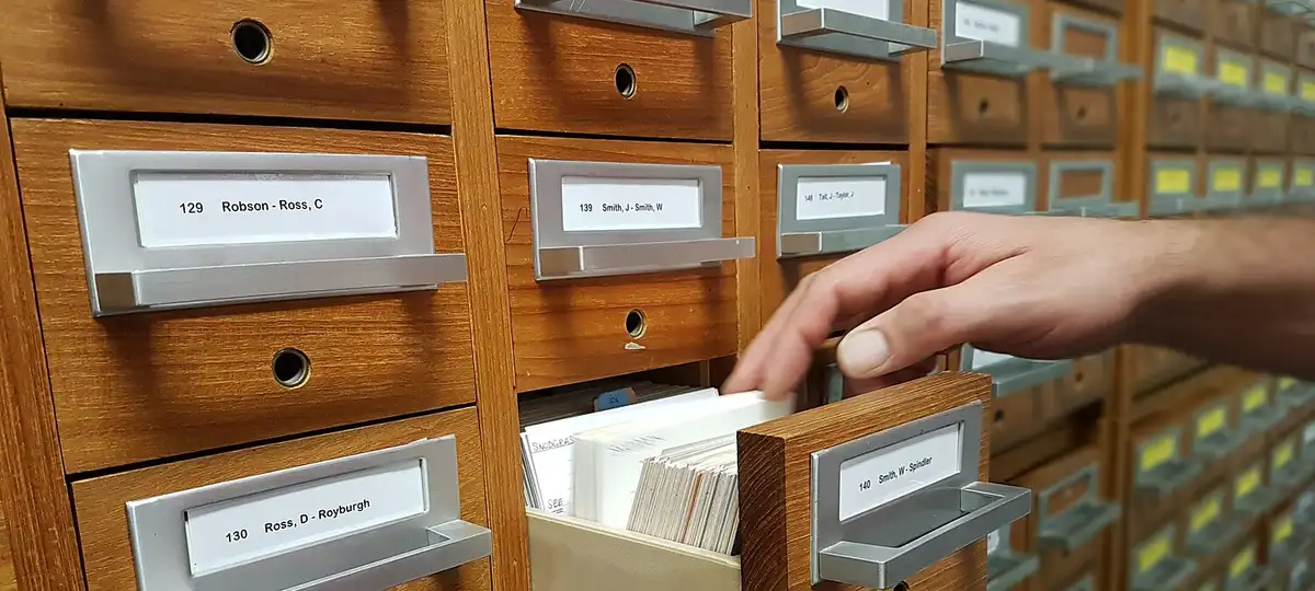 a hand selecting a card in a filing cabinet at a CTC hack weekend